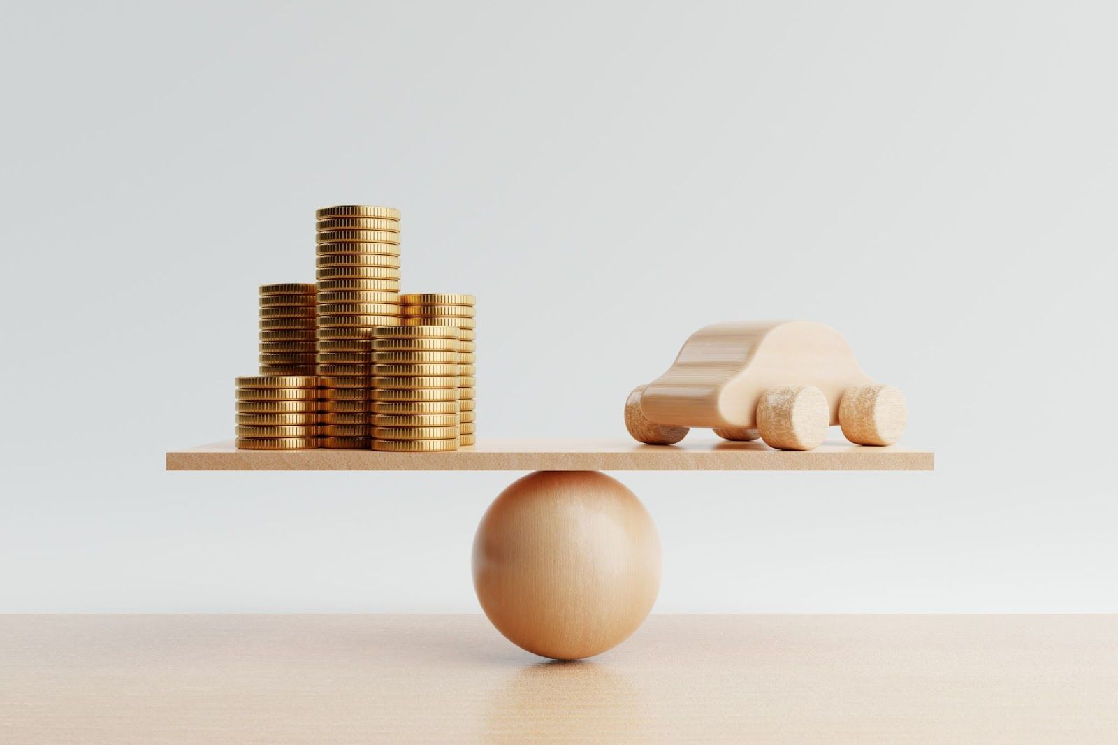 Stack of coins and wooden car balance on a wooden ball, against a white background
