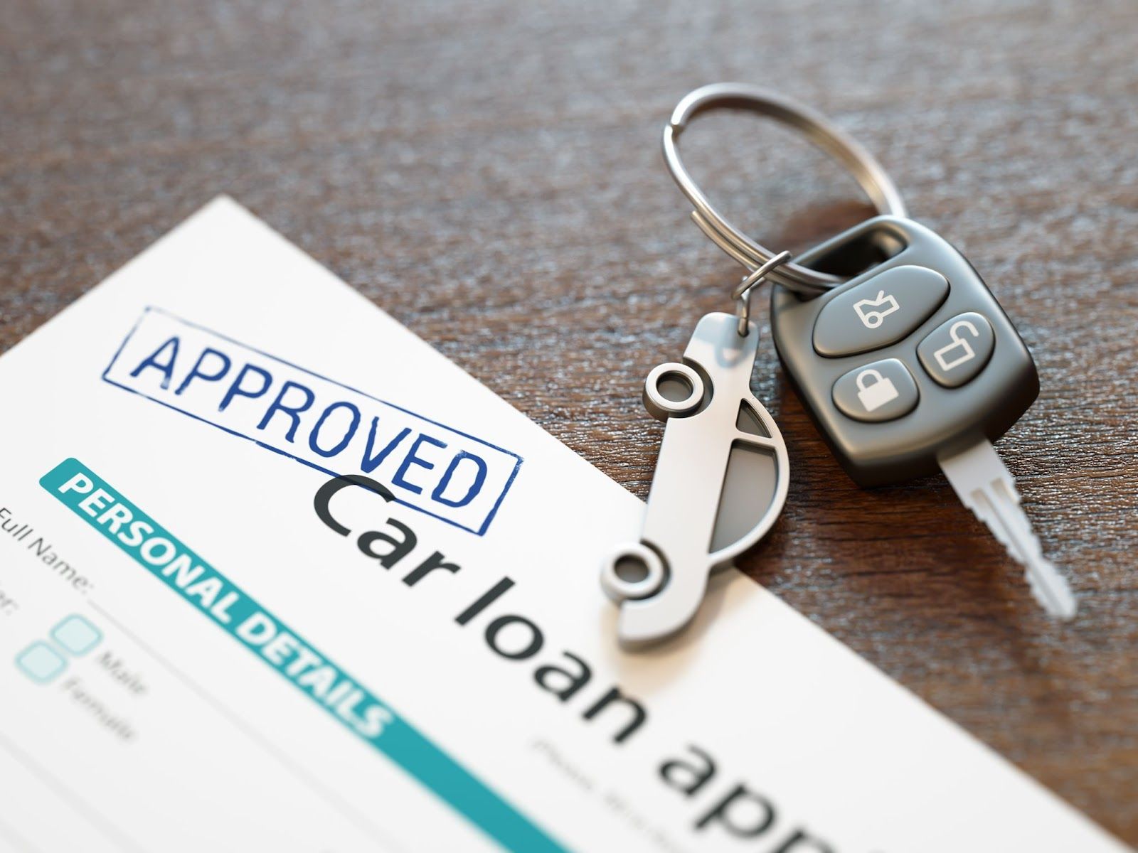 Car key on a keychain rests atop approved car loan application