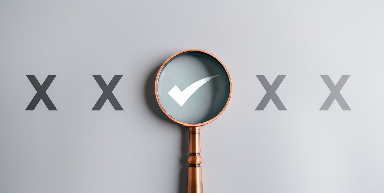 White checkmark under magnifying glass, in a row of gray "X"s