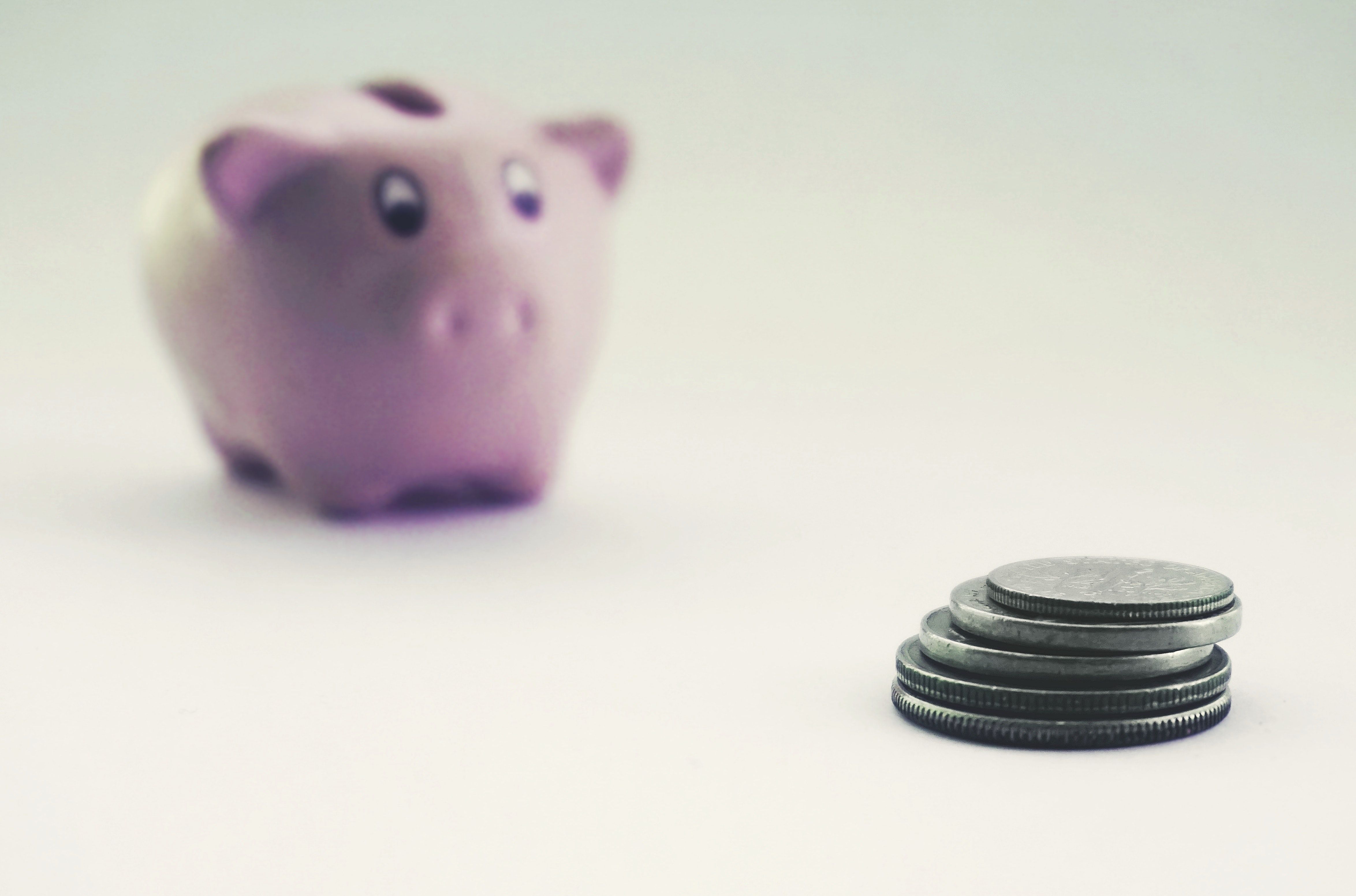 Piggy bank and stack of coins against a white background